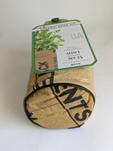 Load image into Gallery viewer, Organic mint herb grow kit in recycled seed sack bag shown from bottom view with rounded bottom and black piping for stability. This little bag fits perfectly on a window sill. The nice tag adds to the package and makes it look pretty for a perfect gift too.
