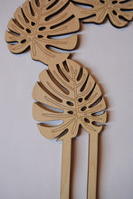 Load image into Gallery viewer, Natural wood color, 1/4" thick, with dark edges, shaped like monstera leaves. This is a close up view showing the engraved lines on the wood leaf.