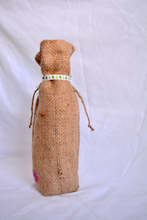 Cargar imagen en el visor de la galería, Burlap wine bag with pink text on the bottom half. This is made from recycled coffee bean sack. The text originally told the origin of the coffee . It ties shut with a festive ribbon.