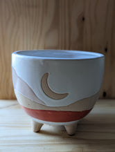 Cargar imagen en el visor de la galería, Boho/Southwest style desertscape planter , 6 inch ceramic footed pot. White glaze over tan features a crescent moon with hand painted wavy lines in tan and red orange to represent the desert scape. 
