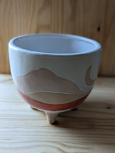 Cargar imagen en el visor de la galería, Boho/Southwest style desertscape planter , 6 inch ceramic footed pot. White glaze over tan features a sun with hand painted wavy lines in tan and red orange to represent the desert scape. 
