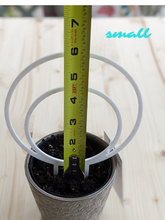 Load image into Gallery viewer, Small, white, double hoop trellis shown in 4 inch pot. Tape measure shows height of trellis stuck in pot to be about 6 inches, while the outer circle of the hoop itself is 5.5 inches.
