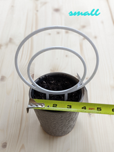 Load image into Gallery viewer, Small, white, double hoop trellis shown in 4 inch pot for scale.  Tape measure shows size of pot.  Hoop is 5.5 inches. 
