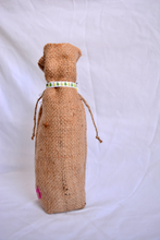 Cargar imagen en el visor de la galería, Burlap wine bag with pink text on the bottom half.  This is made from recycled coffee bean sack. The text originally told the origin of the coffee . It ties shut with a festive ribbon.
